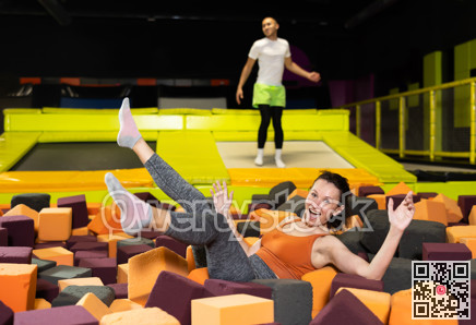 Woman laughing while landing in foam pit at trampoline park