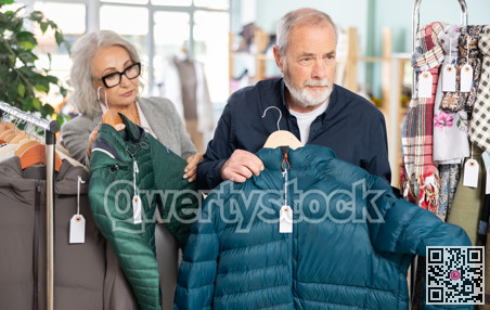 Family clothing store, senior couple customer chooses down jacket