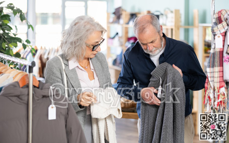 Mature man and woman buying a sweater in a store