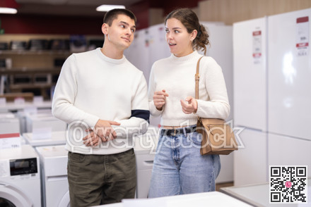 Young couple choosing washing machine or dishwasher