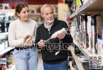 Young woman with elderly man choosing blender in store