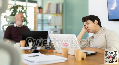 Tired male office workers having nap while sitting in workplace