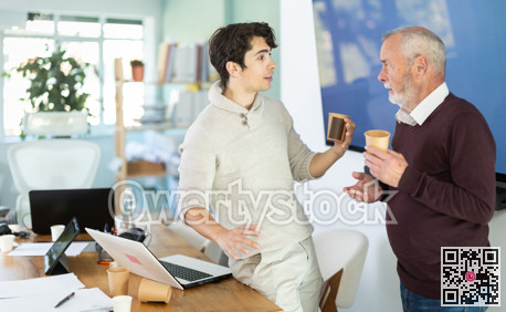 Male colleagues drink coffee and have nice conversation during break