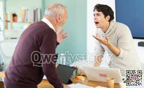 Elderly and young men arguing loudly in office