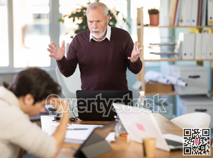 Senior man head of department shouts at guy subordinate who is working with documents