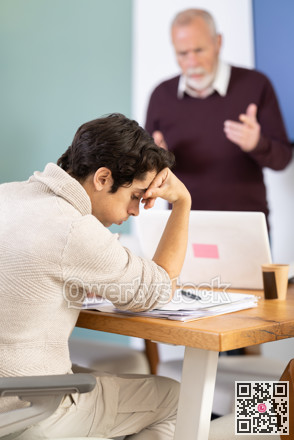 Senior man head of department shouts at guy subordinate who is working with documents