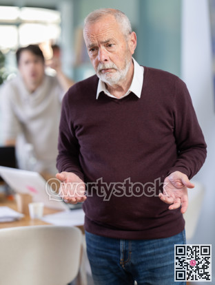 Young man scolds elderly man in office