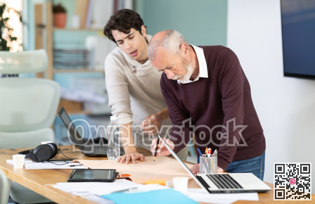 Young and elderly men colleagues discussing building plan in office