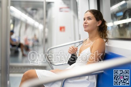 Pleased young girl sitting in wagon travelling by subway