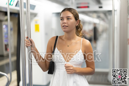 Calm young girl standing on wagon travelling by subway