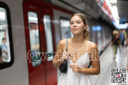 Young girl standing on platform of underground station