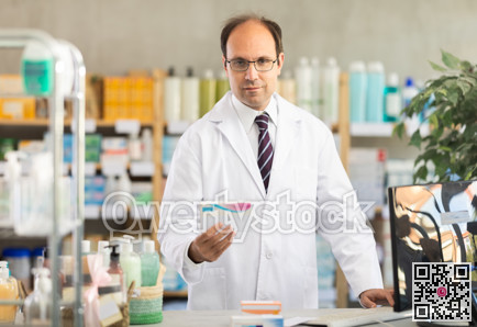 Male pharmacist offering pills in pharmacy
