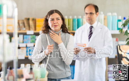 Male pharmacist offering throat pain pills to woman