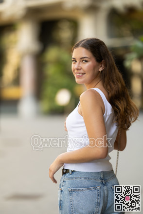 Young smiling girl walks along city street