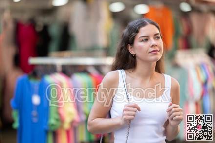 Young brunette browsing clothing stalls during city walk