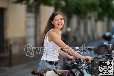 Young girl parks her bicycle on street after walking around city