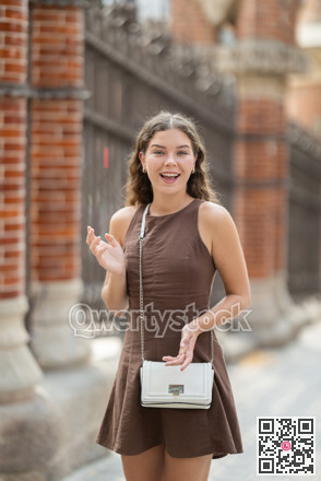 Young woman standing near the metal fence