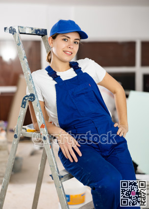 Smiling woman repairer at stepladder inside apartment