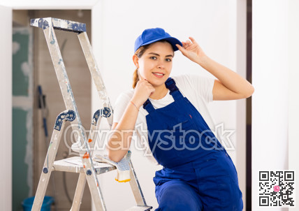 Enthusiastic young female builder inside house under construction