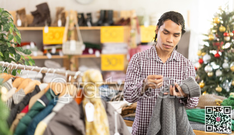 In chain shop, Indonesian man choose sweater, X mas shopping