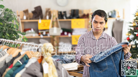 In chain shop, Indonesian man choose jeans, X mas shopping