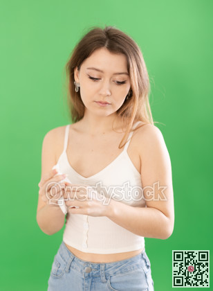 Sad young woman in casual clothes standing on chromakey background