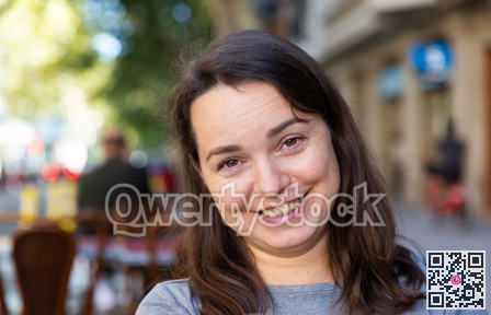 Closeup portrait of cheerful brunette on city street