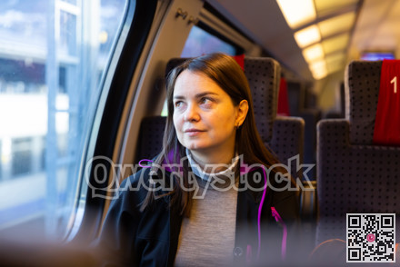 Woman looking through window while traveling by train
