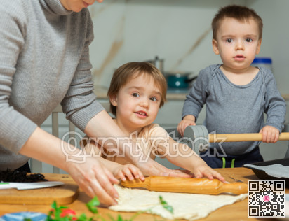 Family are cooking pizza together in cozy home kitchen. Cute kids with happy mother are preparing food or meal for dinner