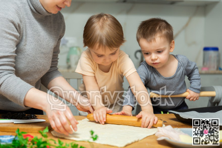Toddler children help mom cook pizza