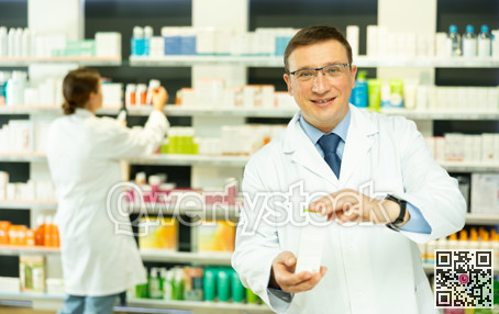 Middle-aged male pharmacist demonstrating preparation in box