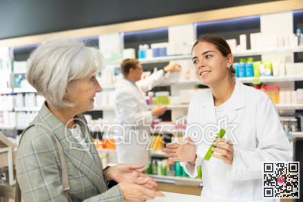Young female pharmacist consulting old costumer about care product in box