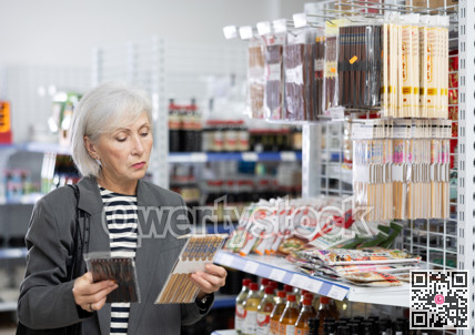Mature woman customer chooses Chinese chopsticks in oriental goods department.