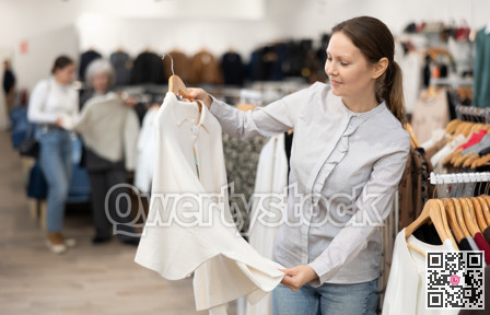 Satisfied woman trying on a new jacket in clothing boutique