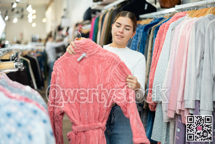 Happy woman shopping new bathrobe at fashion store sales