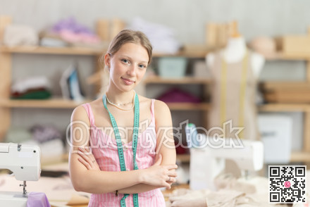 Young female dressmaker welcoming clients in sewing workshop