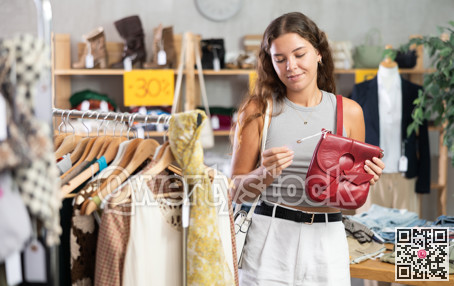 Young women choosing handbag in store