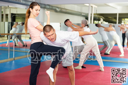 Woman learning knee strike move during self-defense training