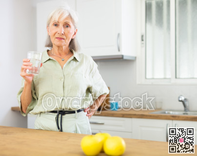 Smiling mature woman with glass of water