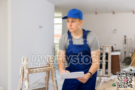 Teenage boy checking documents in construction site