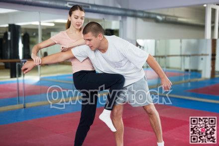 Woman performing knee strike during self-defence training