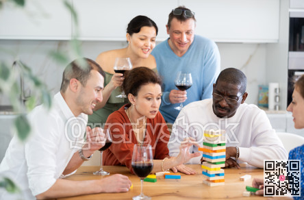 Woman playing jenga with group of friends during home gathering