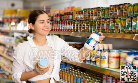 Smiling girl choosing light organic mayonnaise in supermarket
