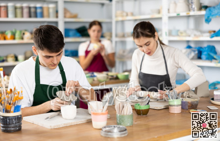 Concentrated young man and woman sculpting handmade cups