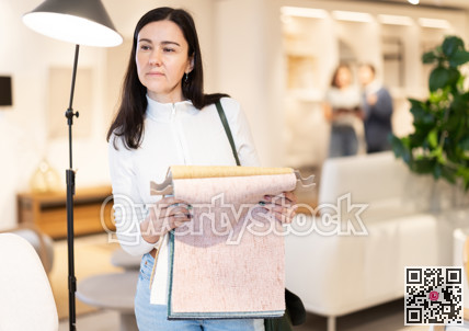 Woman deciding on material for couch in furniture shop