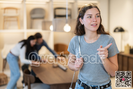 Young woman choosing decoration in furniture salon