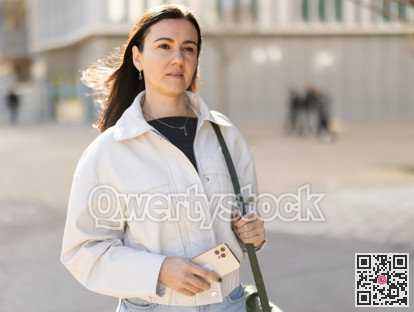 Girl traveler with phone walks through tourist area of town