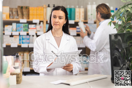Female pharmacist filling out papers in pharmacy