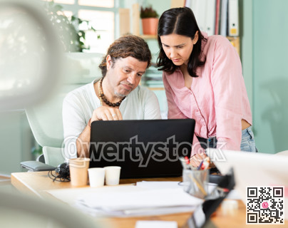 Sad man and woman facing problems while working on laptop in office