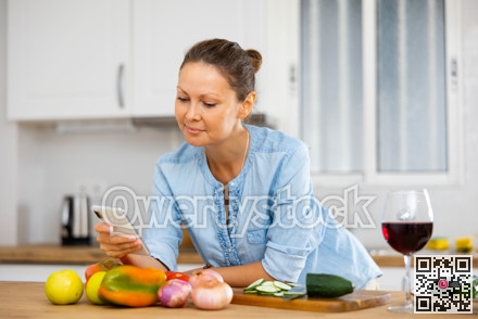 Positive young woman using phone at home